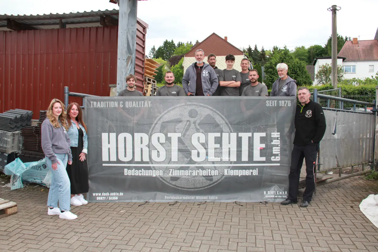 Das Team der Horst Sehte GmbH vor dem Firmenbanner